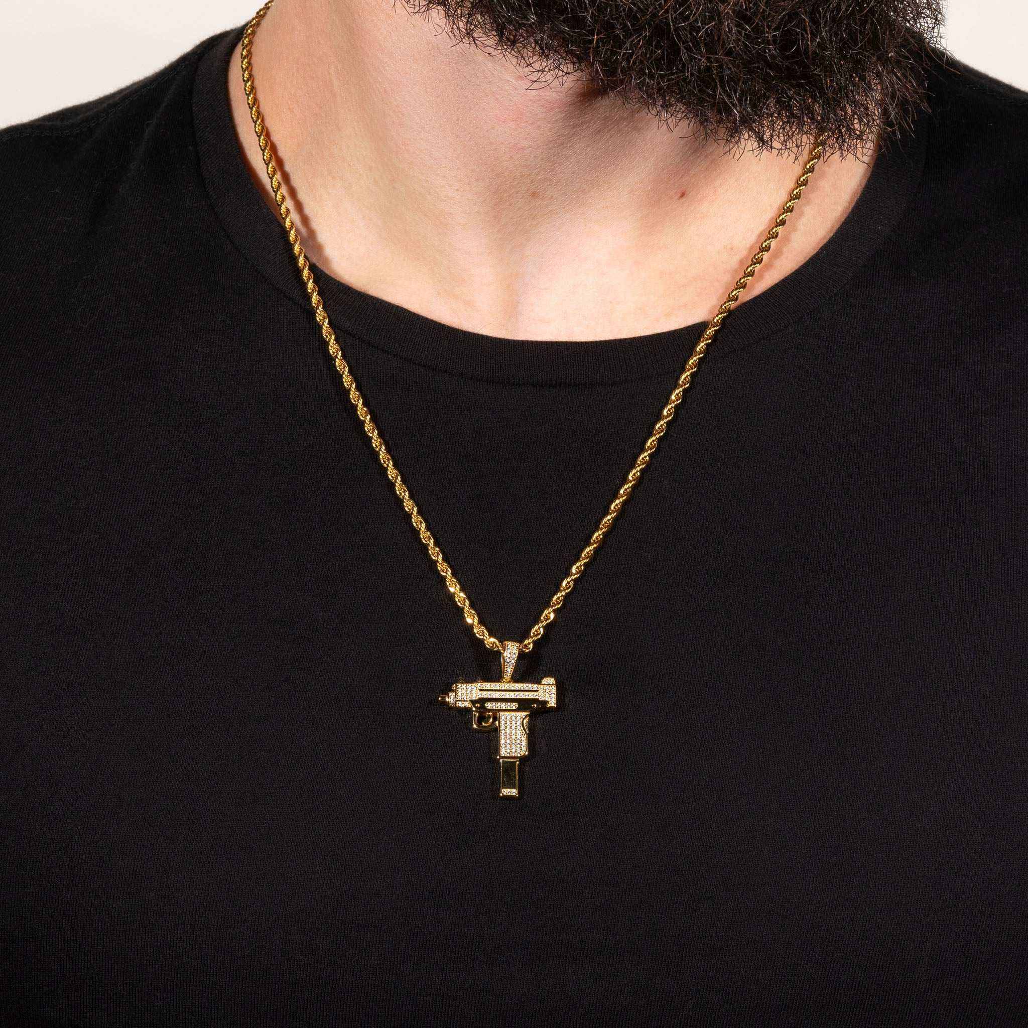 Uzi Pendant on a gold chain around a man's neck, featuring handset clear cz stones and crafted from 100% pure 925 silver.