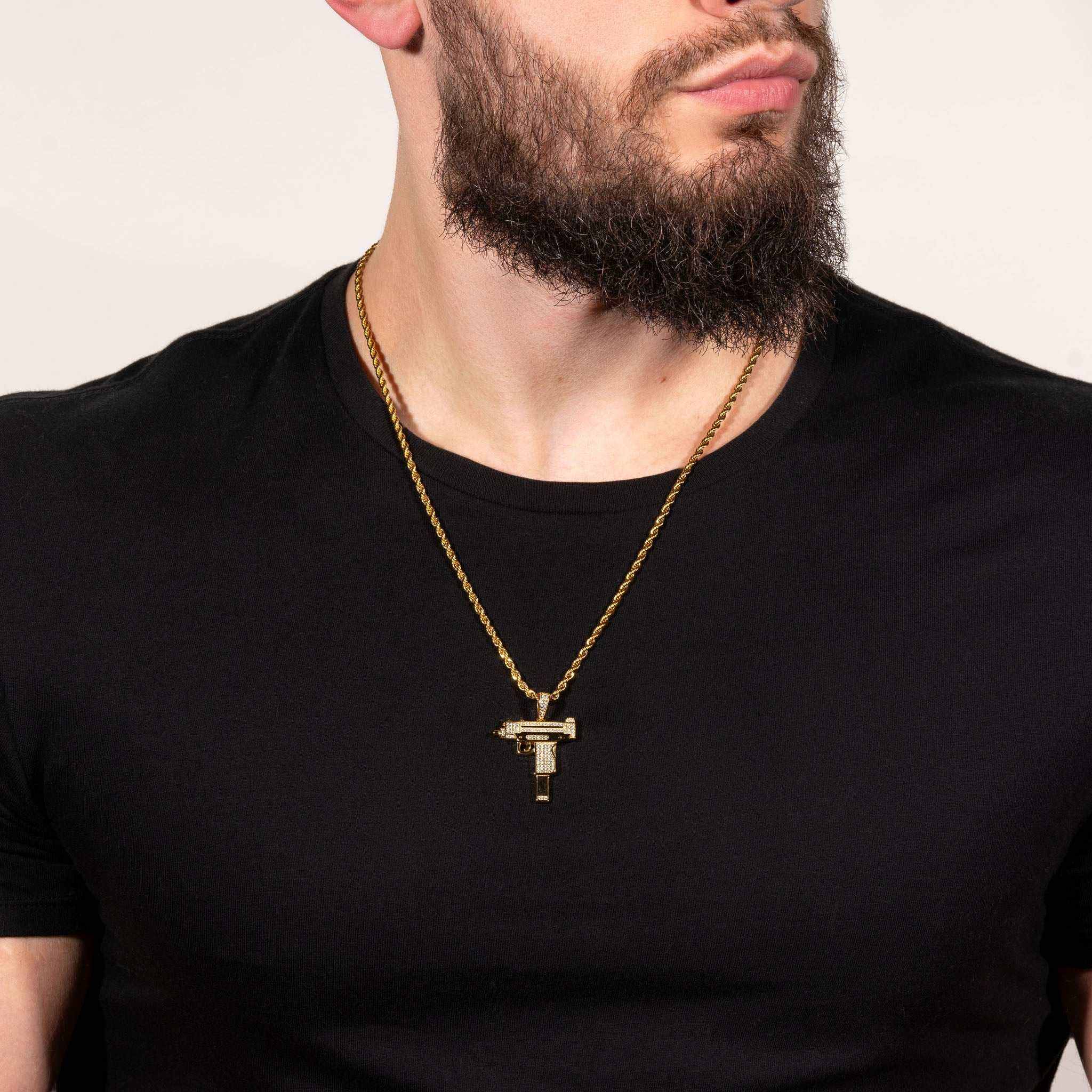 Man wearing Uzi Pendant on a chain, featuring rhodium or 14k yellow gold-plating with clear cz stones, crafted in pure 925 silver.