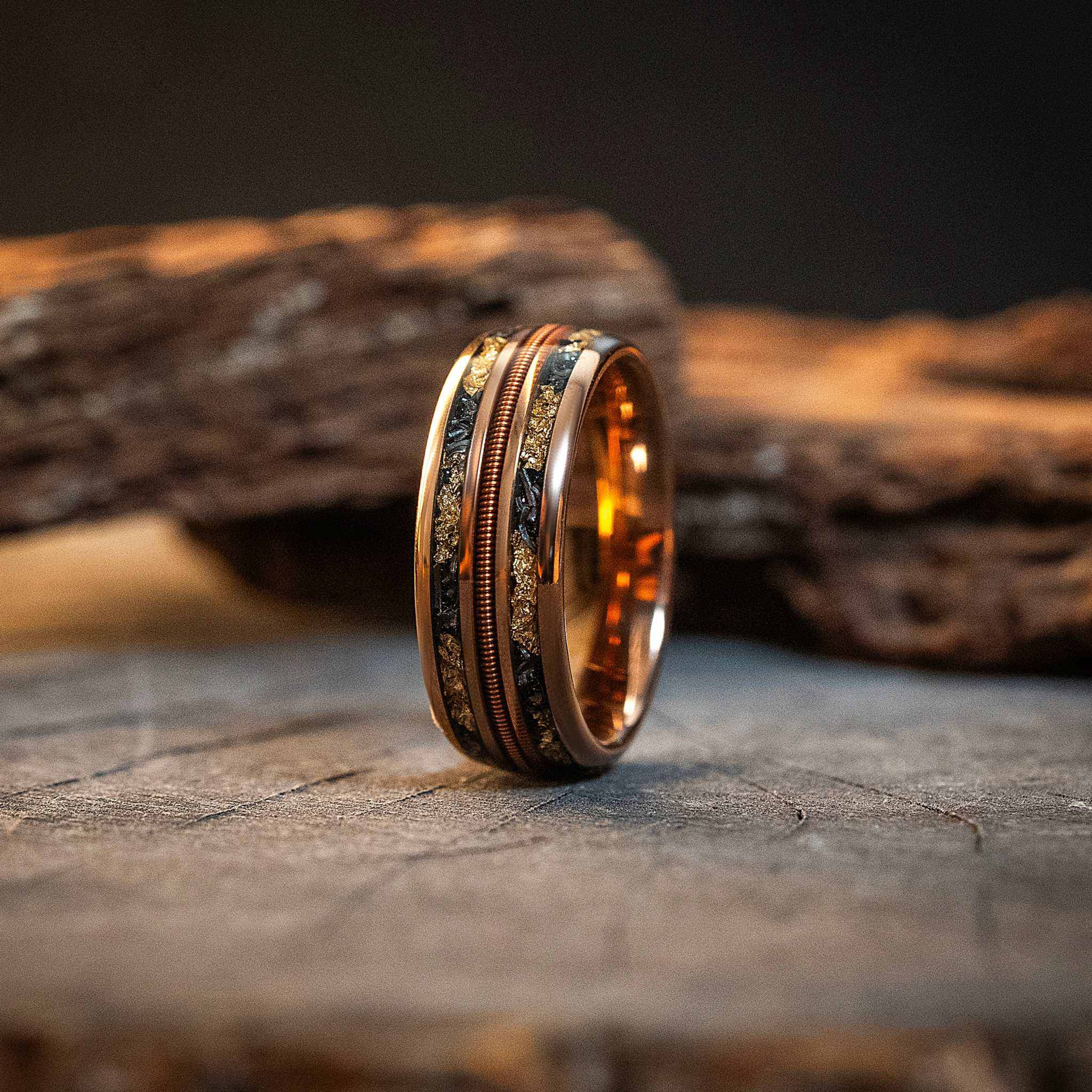 Tungsten carbide ring with authentic meteorite dust, 24K gold leaf, and guitar string inlays.