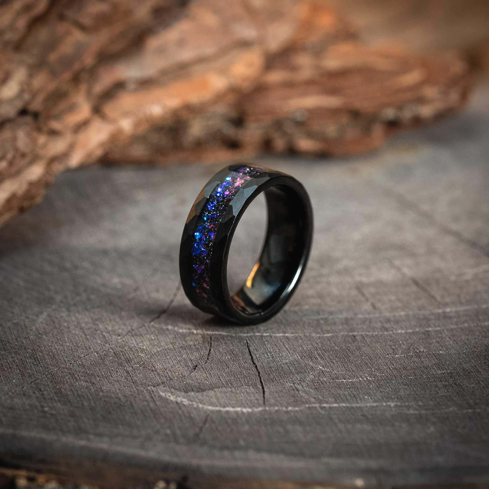 Black Hammered Nebula Meteorite Ring with Galaxy Blue Sandstone Inlay on rustic wood surface.