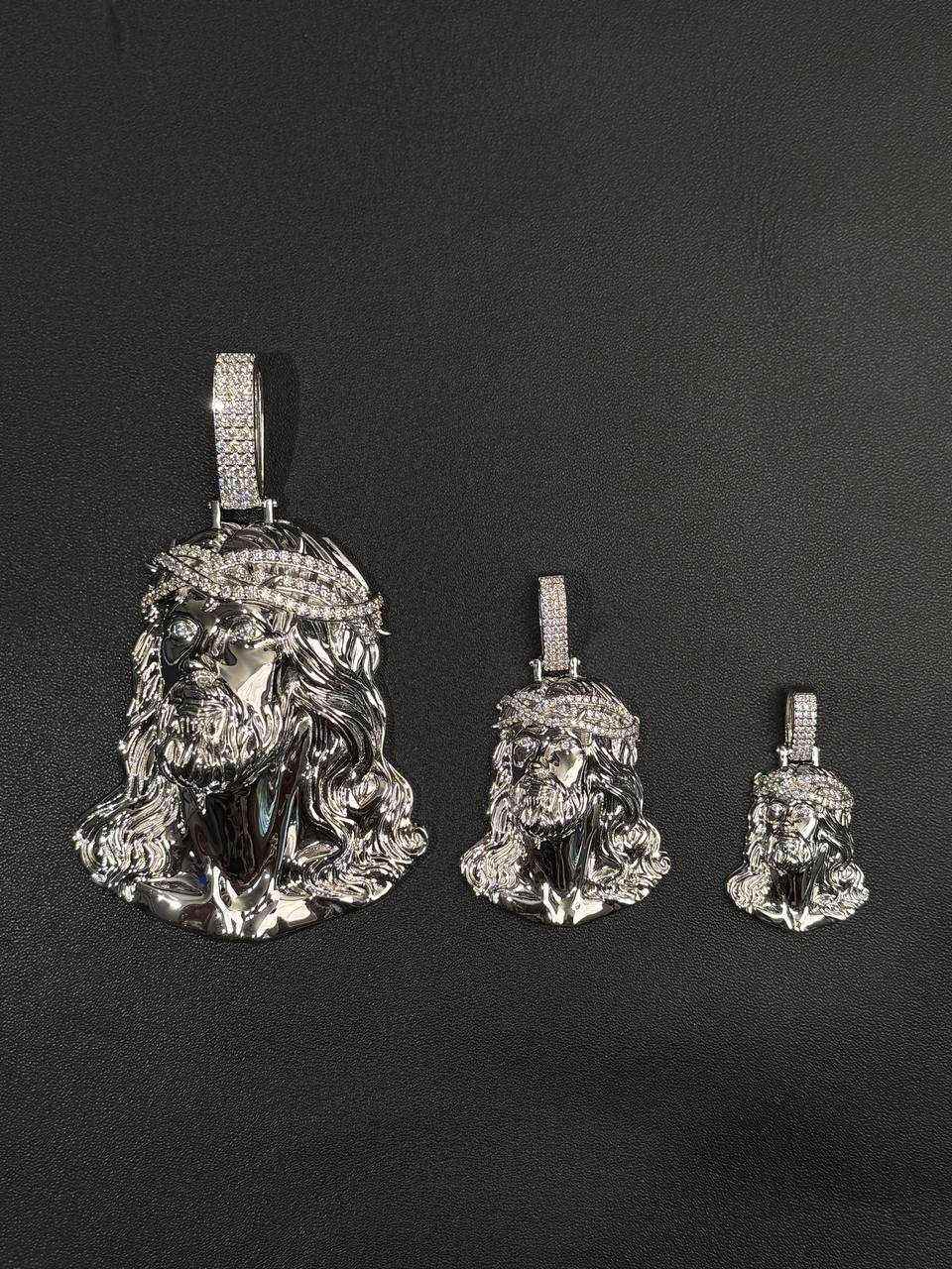 Three sizes of Moissanite Jesus Head Piece pendants in solid 925 sterling silver with rhodium plating and VVS1 D color moissanite stones displayed on black background