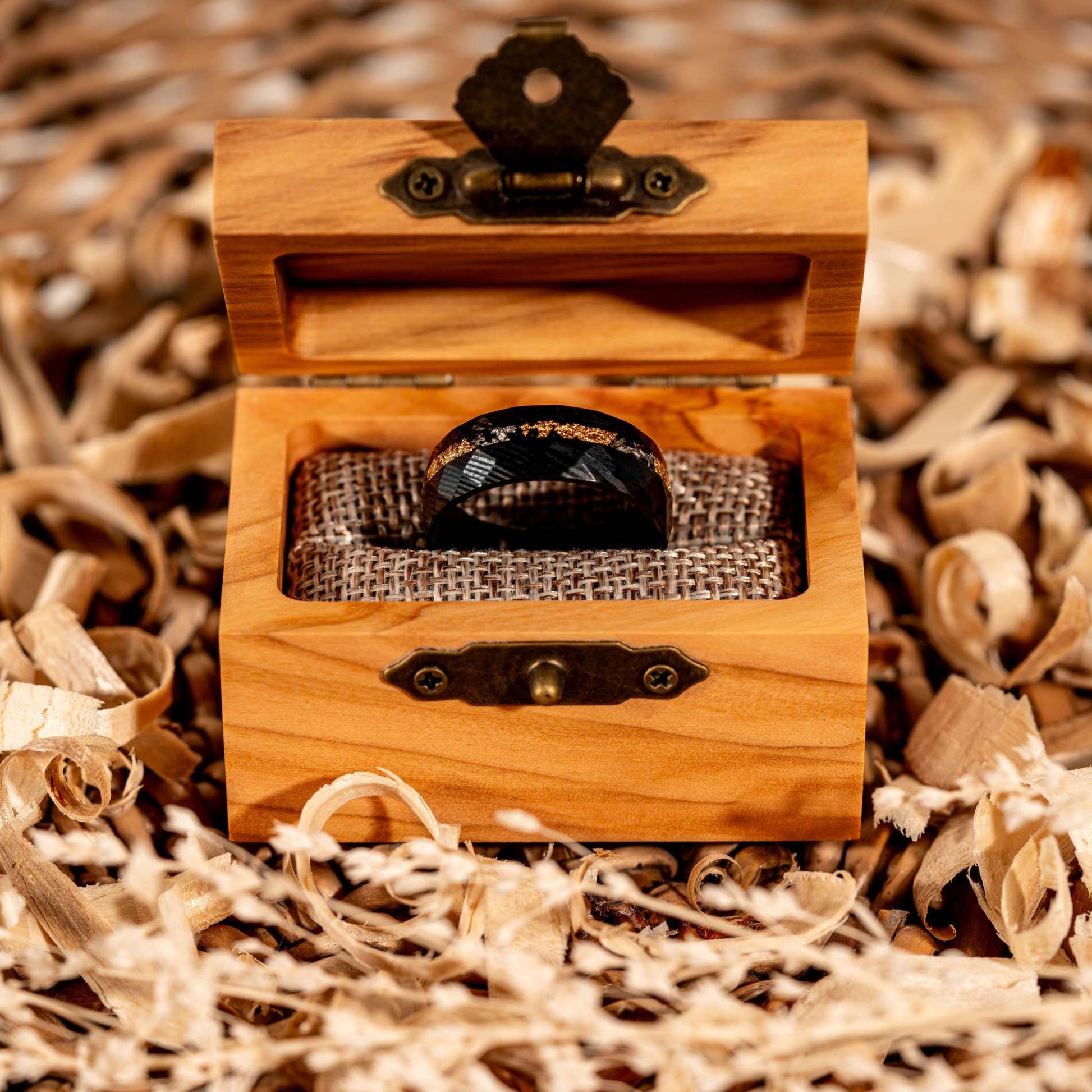 Hammered black steel ring with Damascus meteorite and crushed gold inlay in olive wood box.