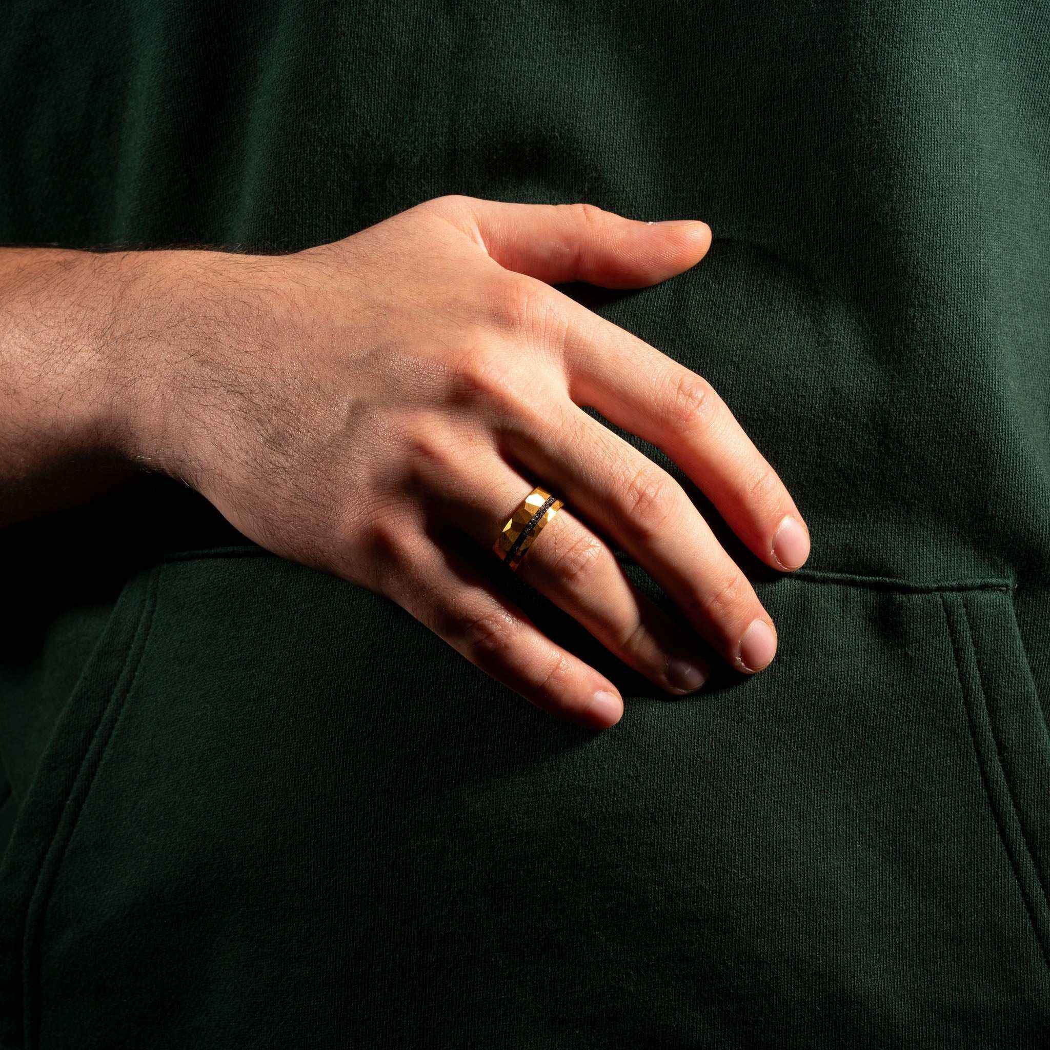 Hand wearing the Infinite Meteorite Ring with gold and meteorite inlay.