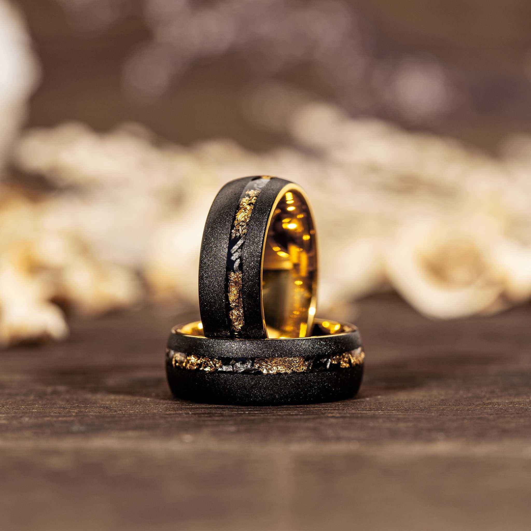 Sandblasted gold leaf meteorite ring on wooden surface.