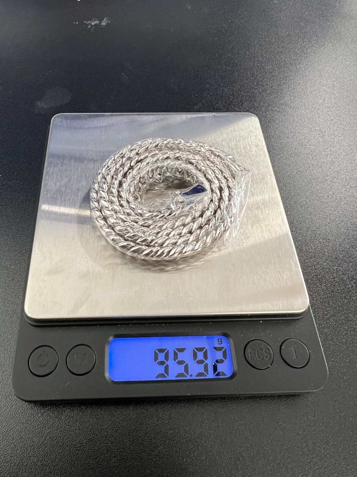 Mens solid 925 sterling silver moissanite Cuban link chain on digital scale showing weight.