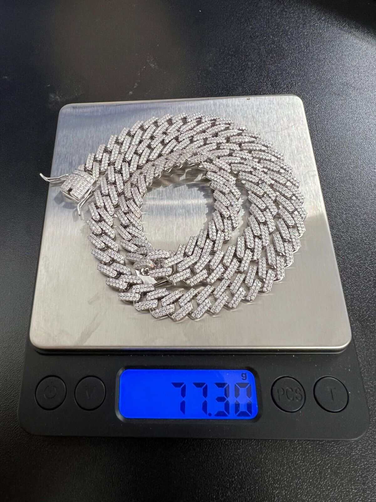 10mm Moissanite Miami Cuban Chain on scale displaying 77.3 grams.