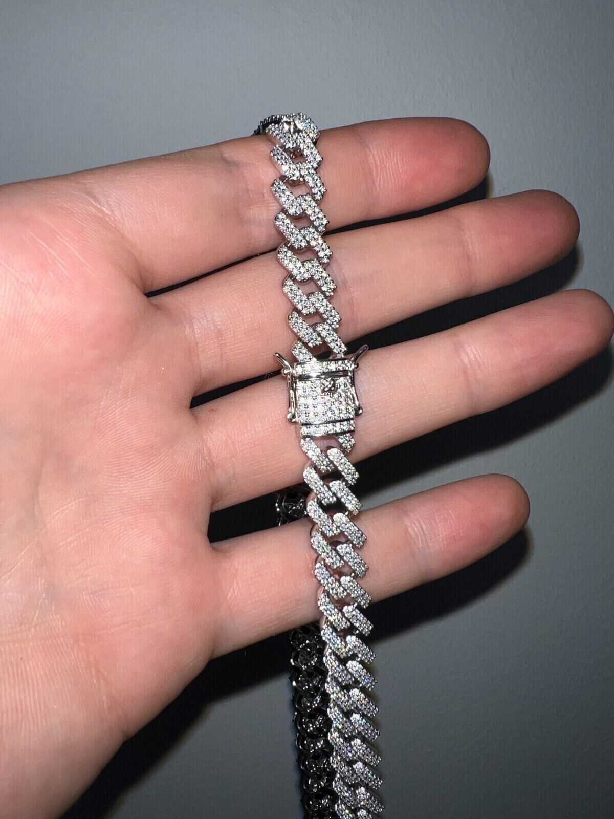 10mm Moissanite Miami Cuban Chain in sterling silver with rhodium finish on hand.