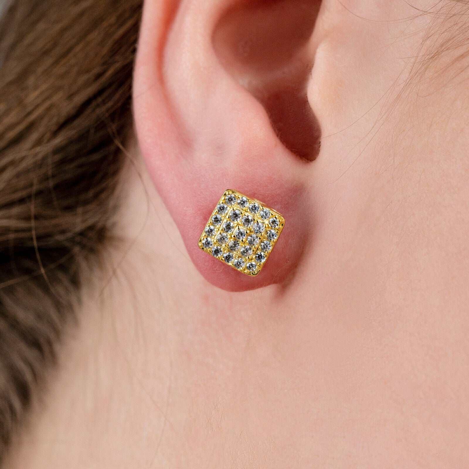 Square shaped stud earrings with cubic zirconia, 14K yellow gold plated, worn on ear.