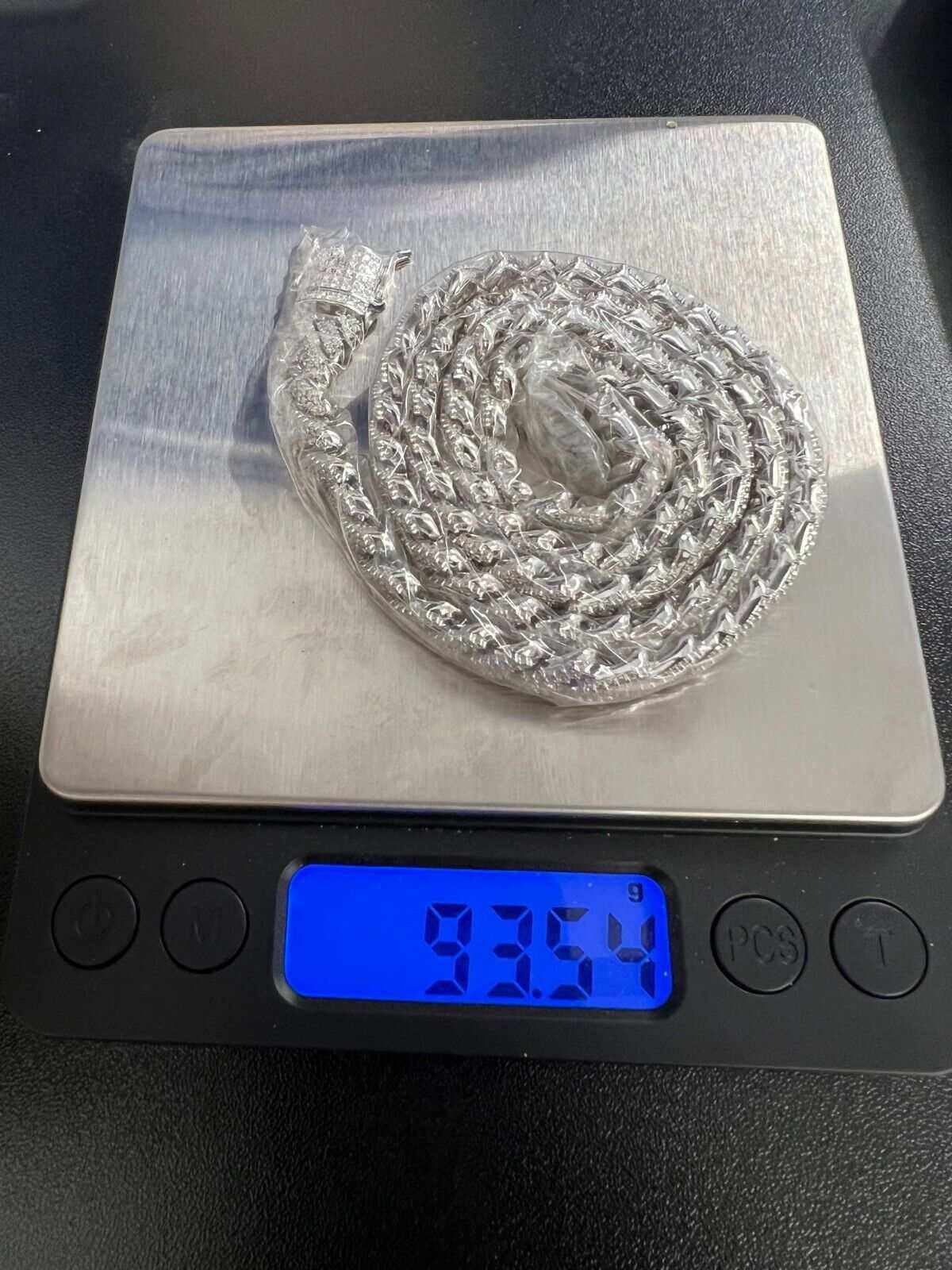 10mm Moissanite Miami Cuban Chain on digital scale displaying 93.54 grams.