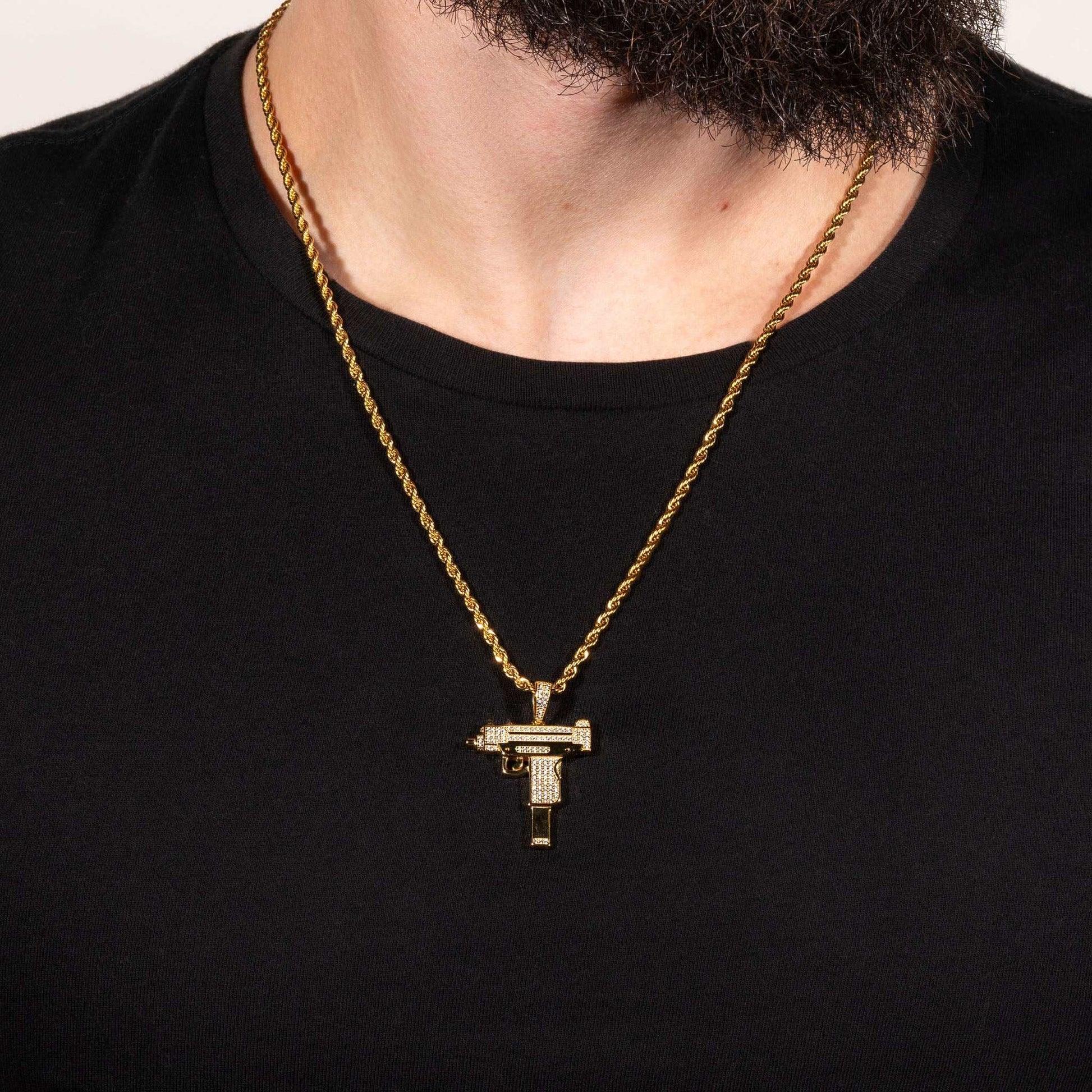 Uzi Pendant on a gold chain around a man's neck, featuring handset clear cz stones and crafted from 100% pure 925 silver.