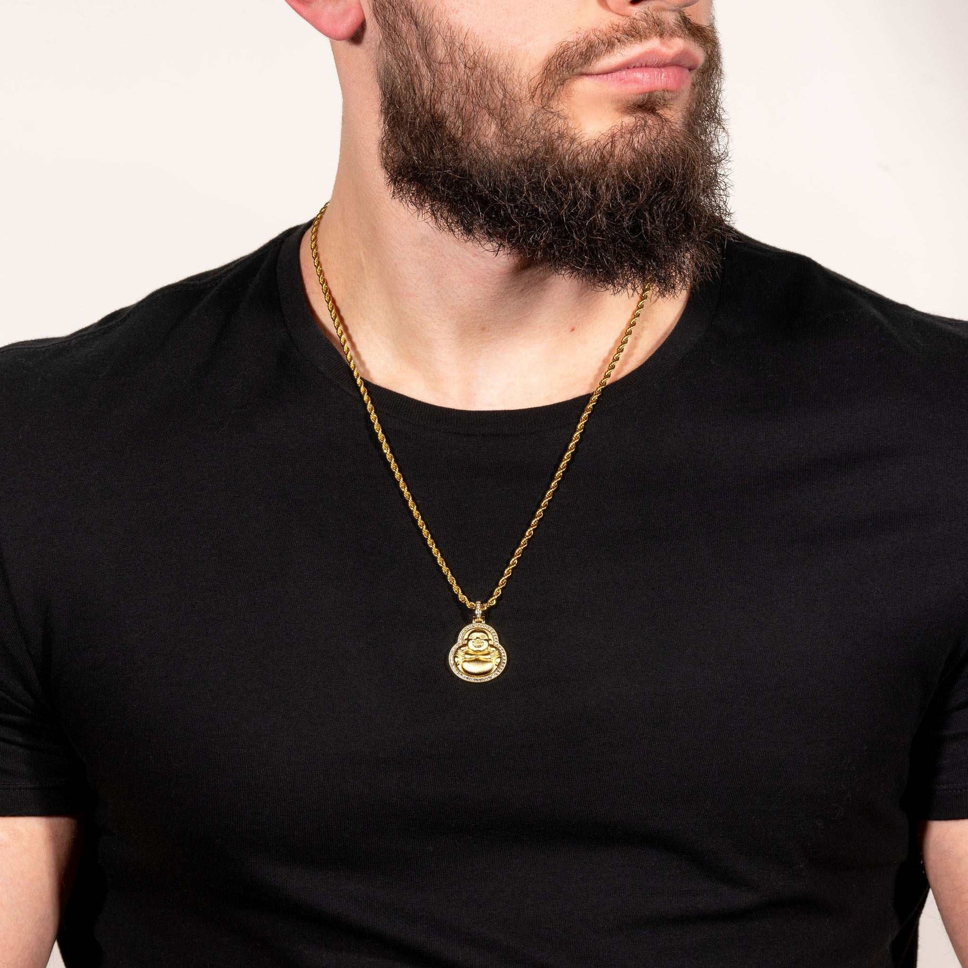Buddha pendant in 14k gold on a man wearing a black shirt.