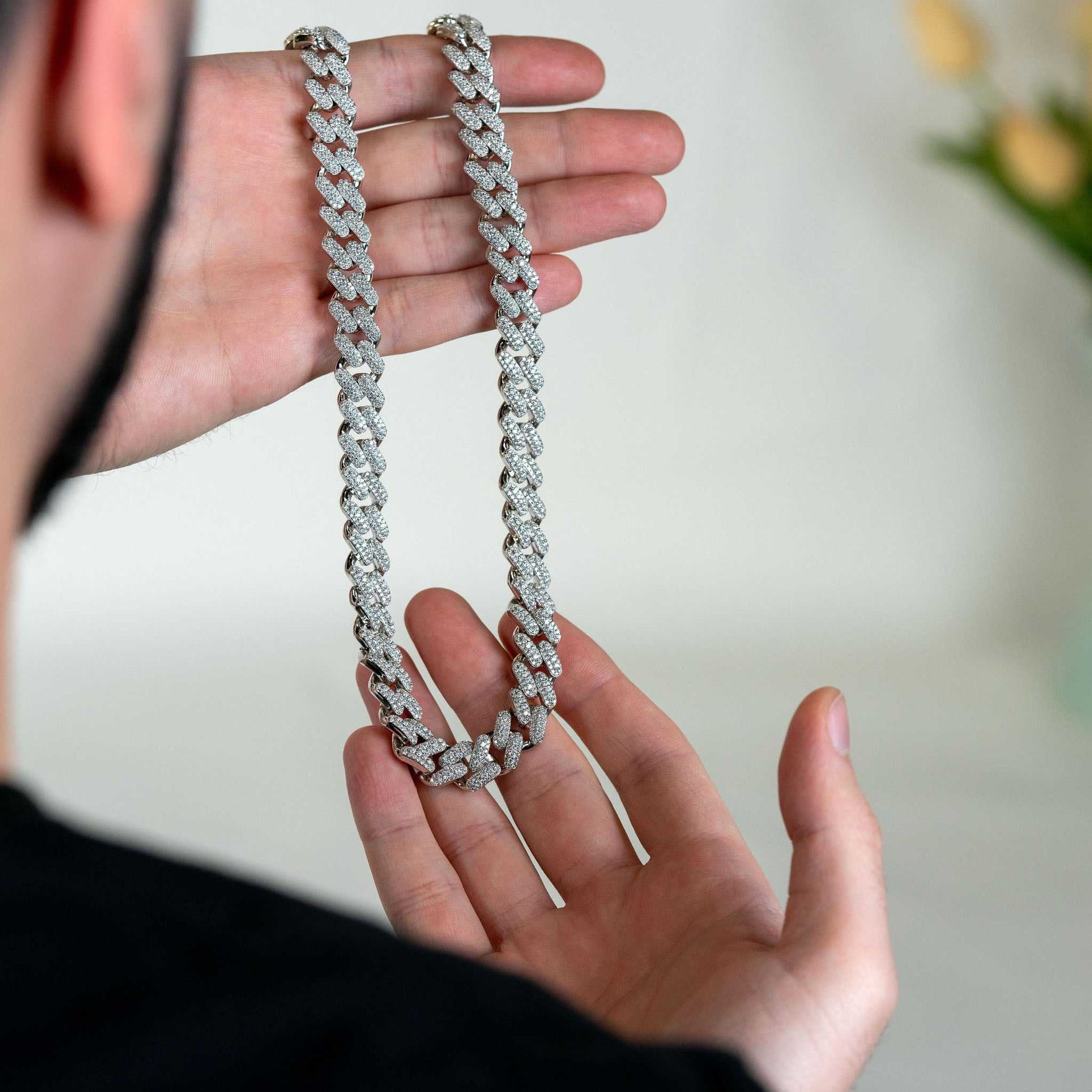 12mm Moissanite Miami Cuban Link Chain in sterling silver, held in hands.