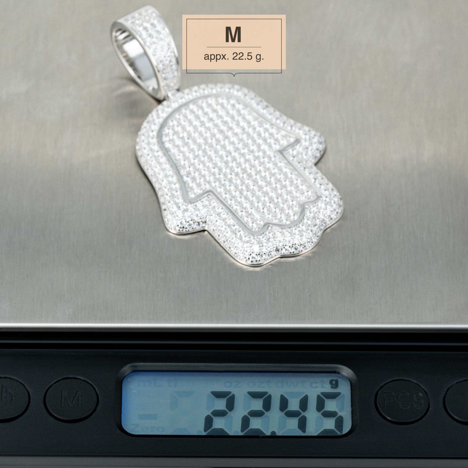 Sterling silver Hand of God Hamsa Pendant on scale, medium size, 22.5g, featuring CZ stones.