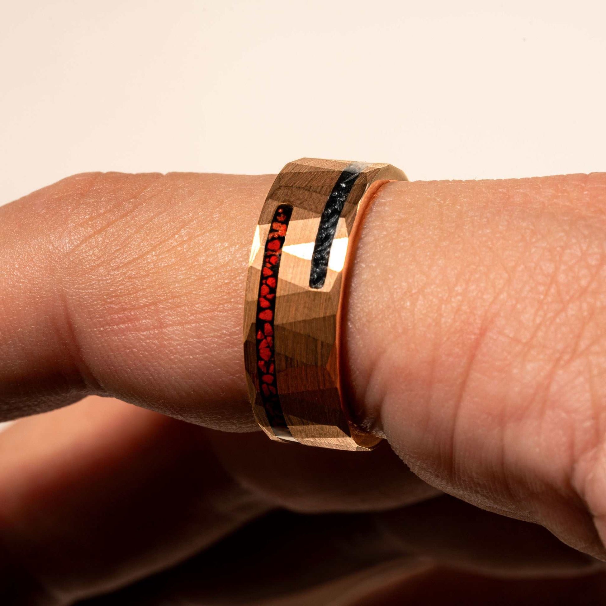 Dinosaur bone and meteorite ring with tungsten band on hand.