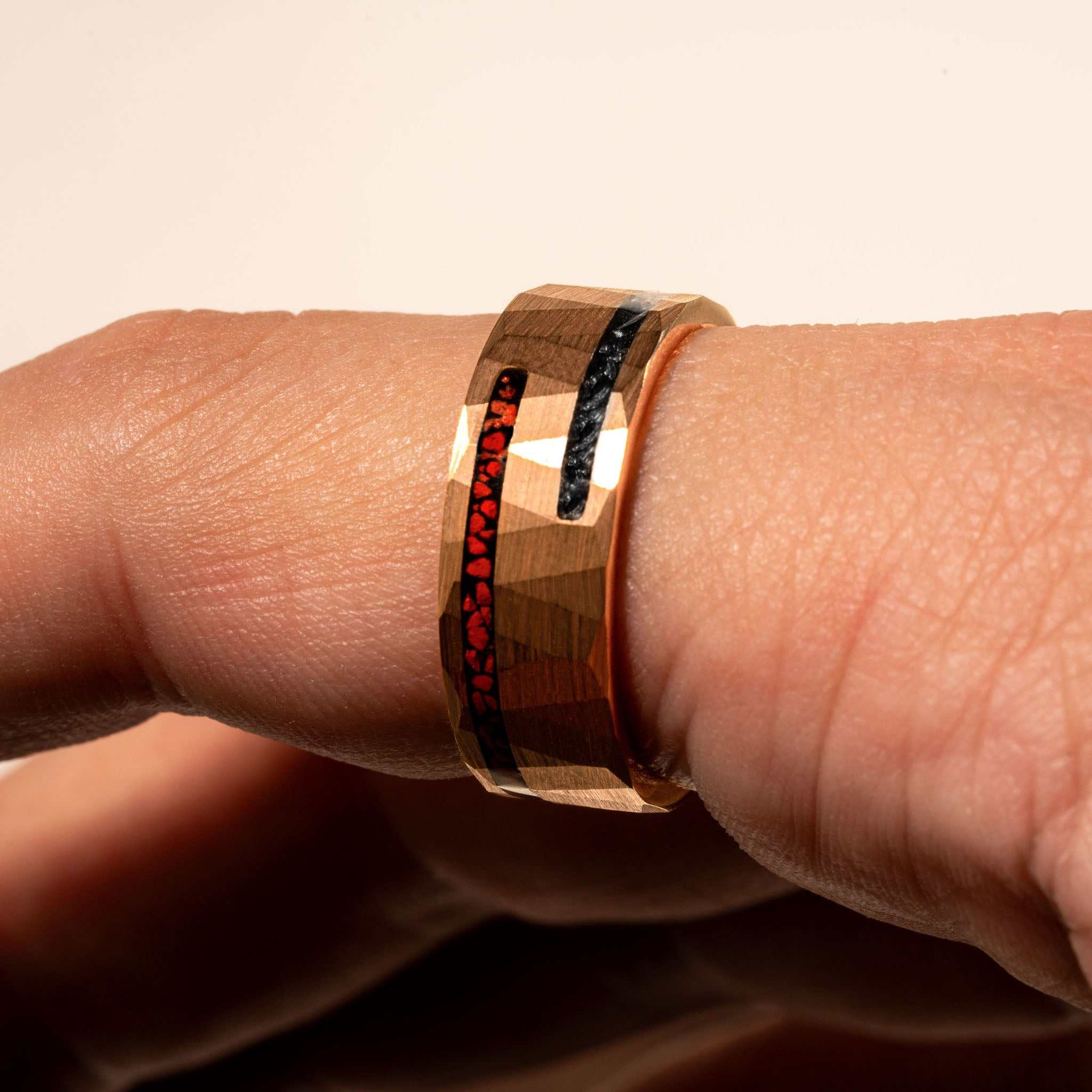 Dinosaur bone and meteorite ring with tungsten band on hand.