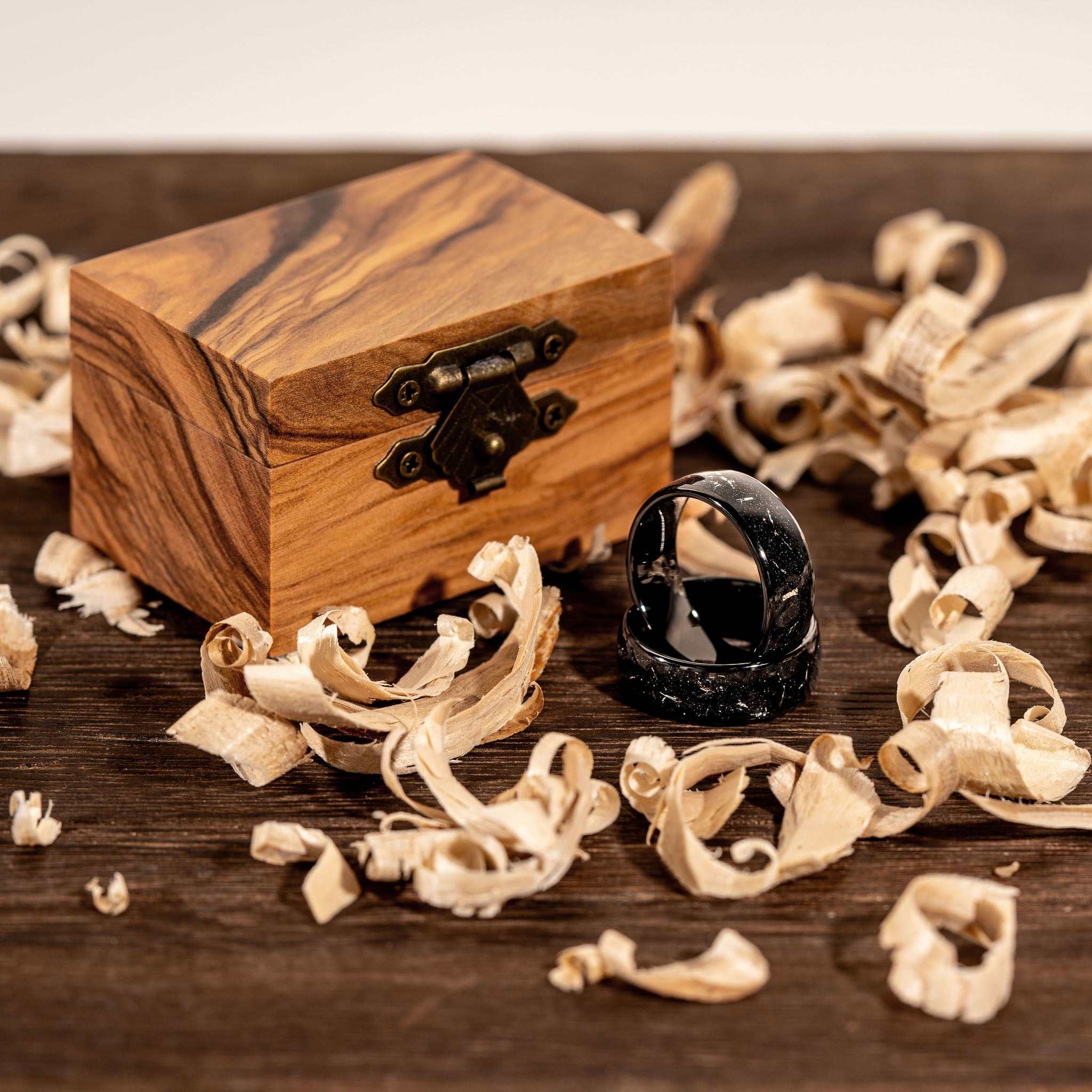 Black Eclipse Galaxy Ring with Tungsten and Meteorite Iron beside a wooden box.
