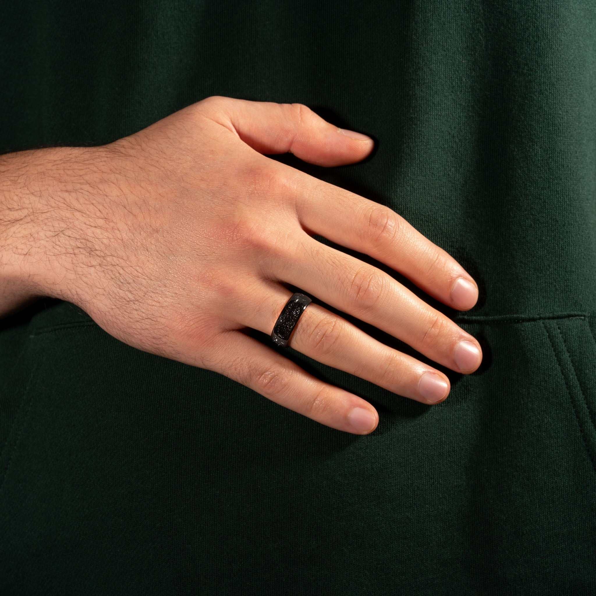 Eclipse Galaxy Ring, black tungsten band with meteorite iron, shown on hand.