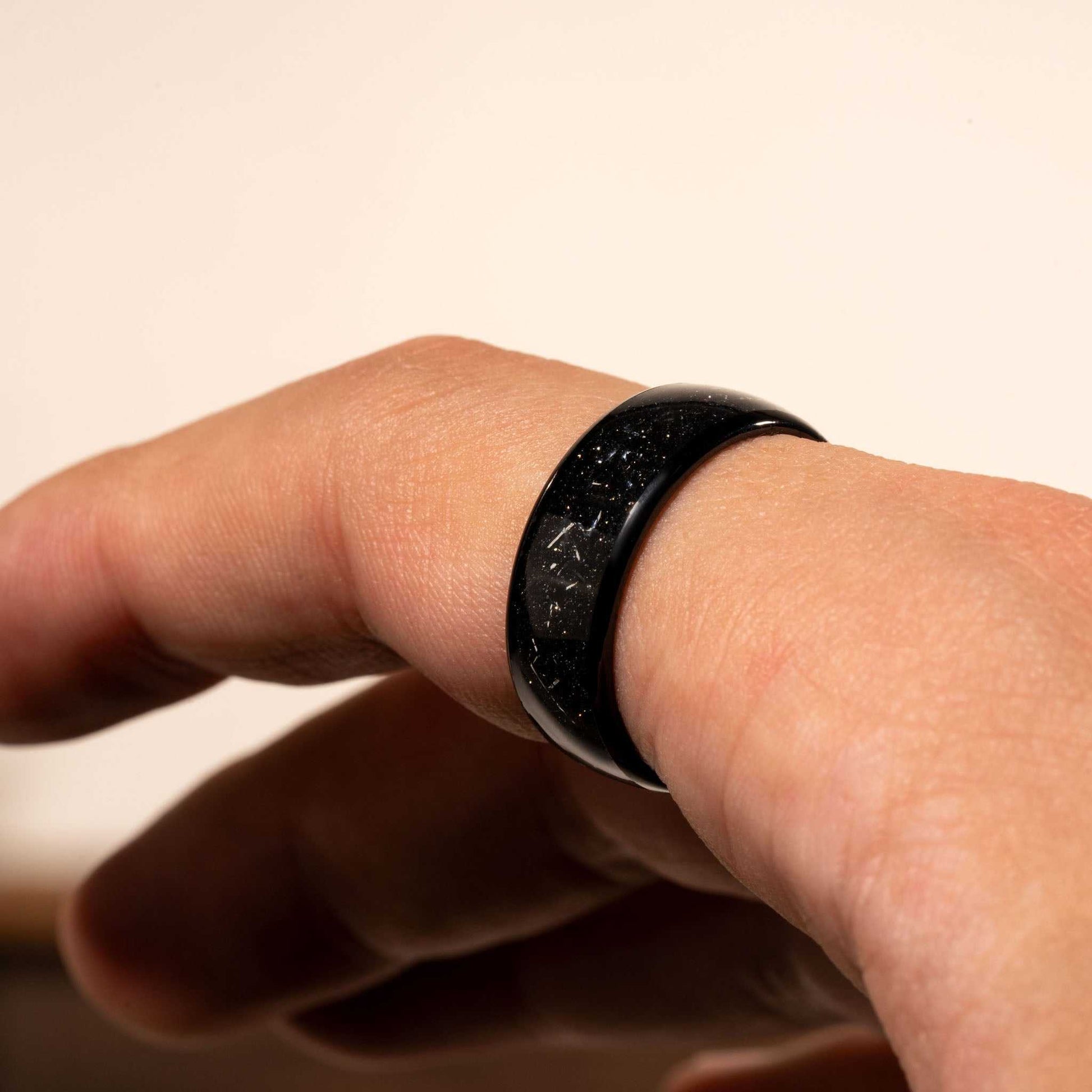 Black Eclipse Galaxy Ring on finger made of tungsten and meteorite iron.
