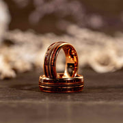 Rose gold and tungsten guitar string whiskey barrel wood ring with intricate inlay and polished finish