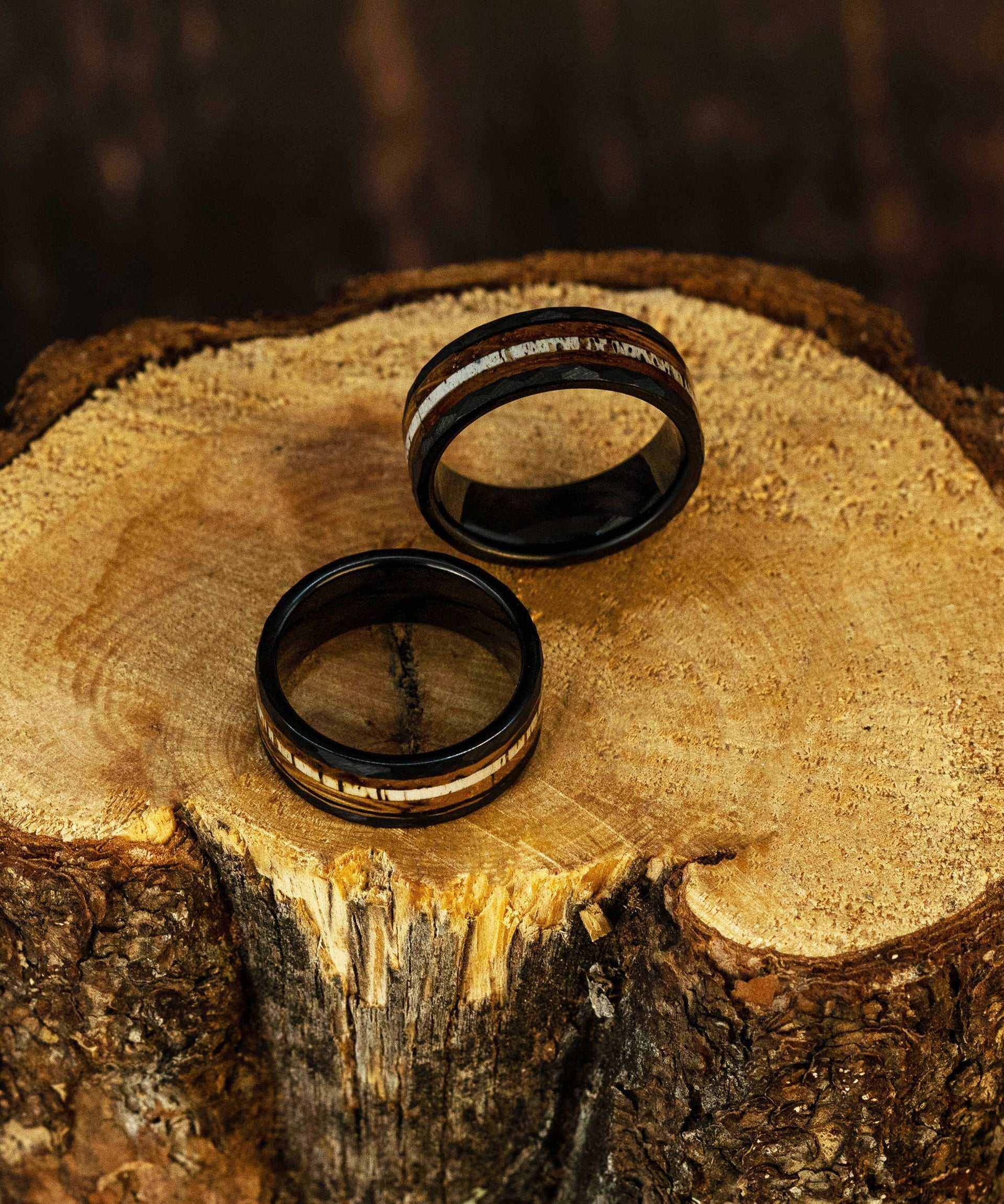 Hammered antler ring on wood surface, tungsten unisex design, comfort-fit.