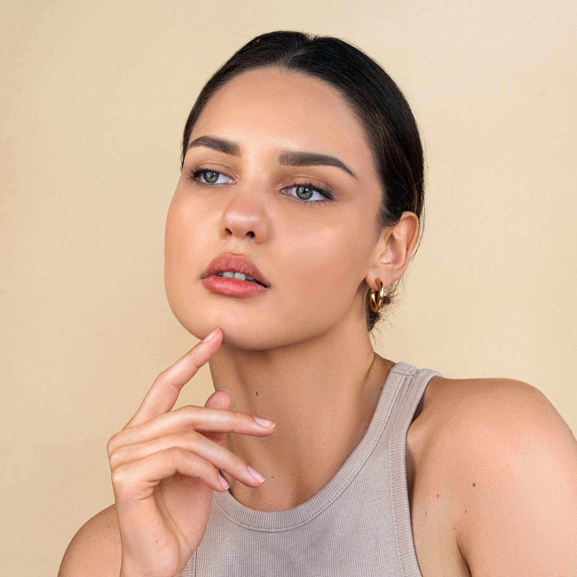Mirage Bold Hoops - 18k PVD gold plated stainless steel earrings worn by a woman, hypoallergenic, waterproof, tarnish-free.