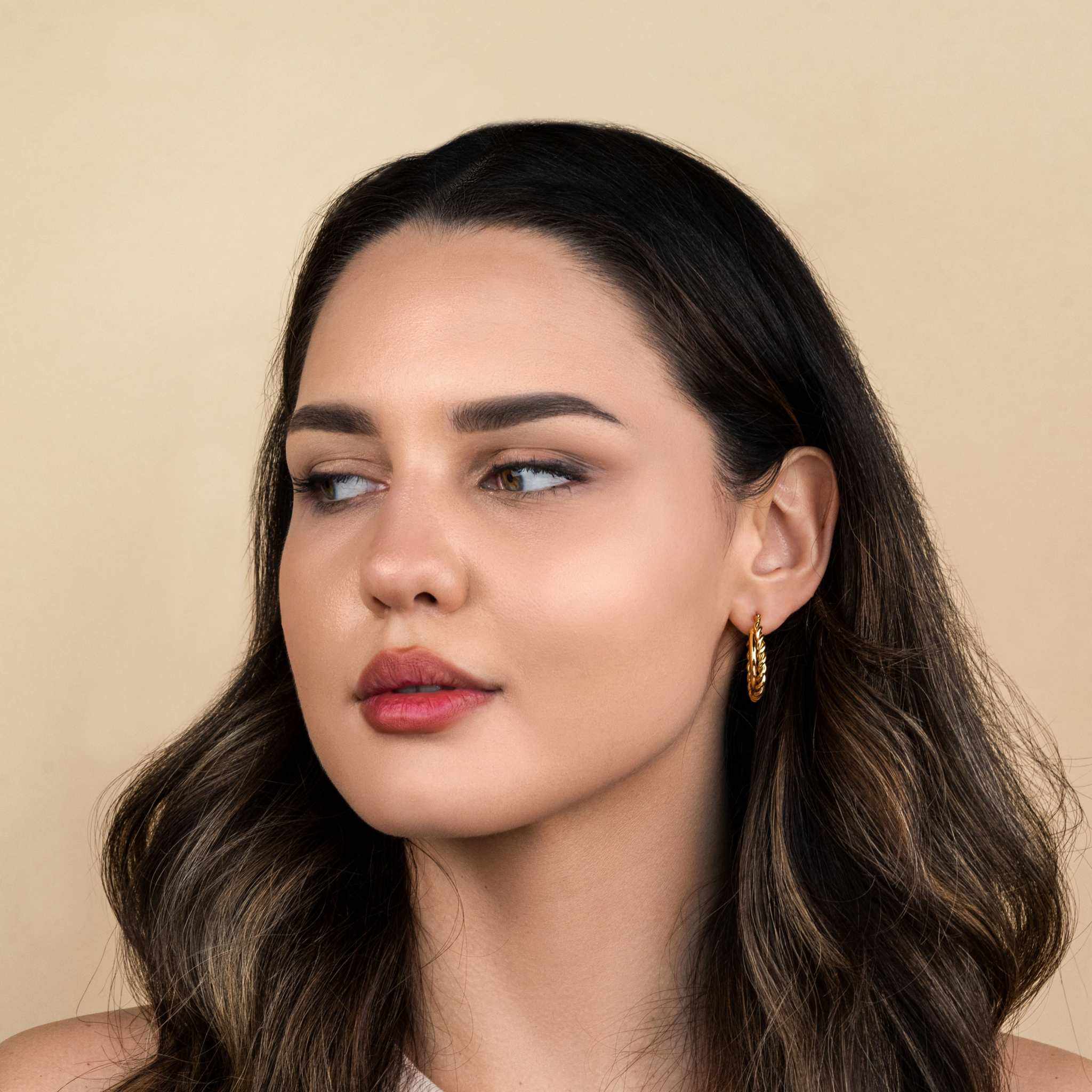Mirage Twisted Hoop Earrings with 18k gold plating and hypoallergenic stainless steel.