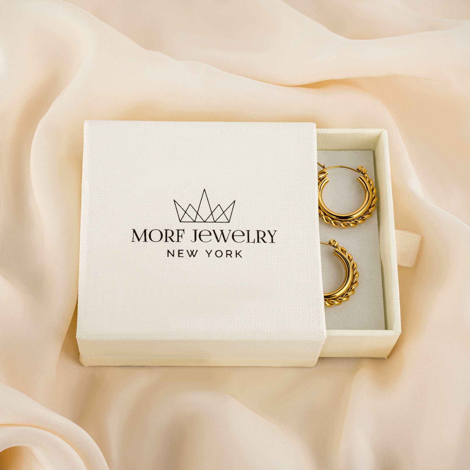 Mirage Twisted Hoop Earrings in gold-plated stainless steel, hypoallergenic and tarnish-free, displayed in a brand box.