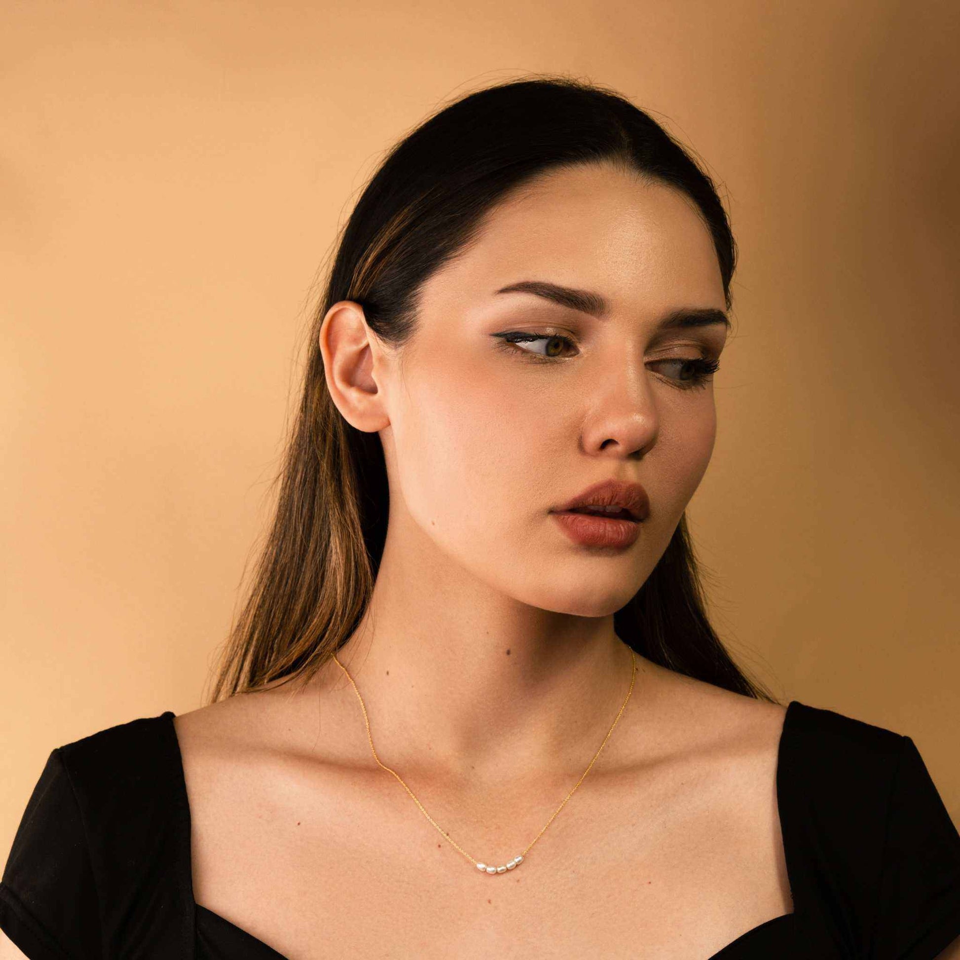 Dainty freshwater pearl bead necklace on woman, 14K gold chain, minimalist jewelry.