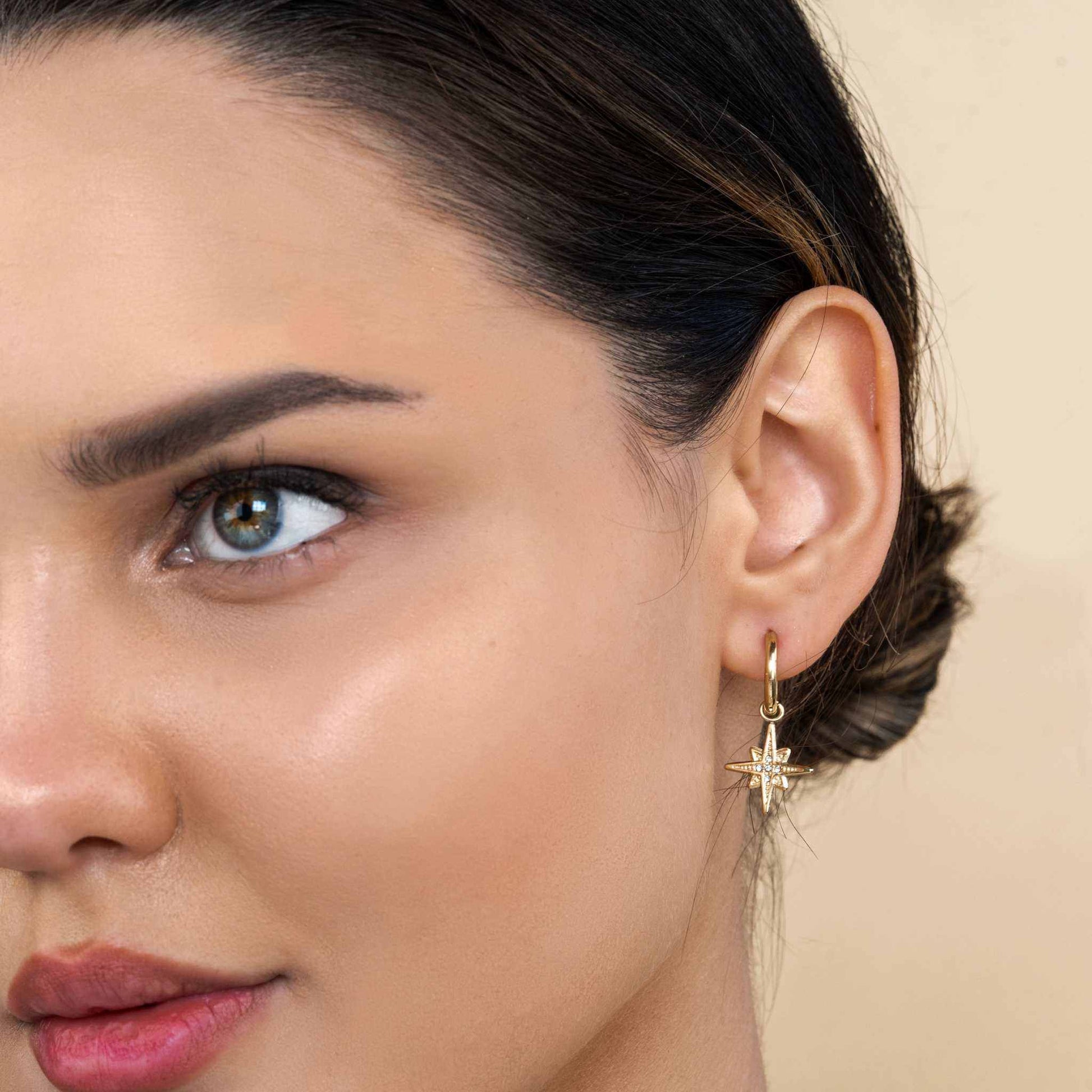 Starburst Huggie Earrings with 18k gold plating displayed on person.