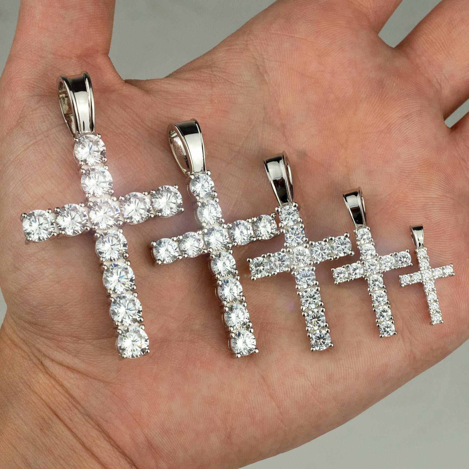 Sterling silver tennis cross pendants with clear CZ stones in various sizes.