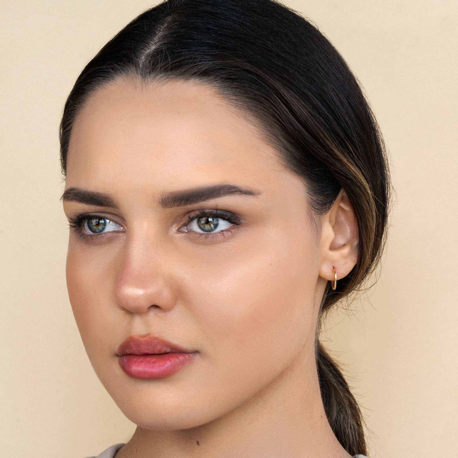 Vivid Hoop Earrings in 18K gold on model.