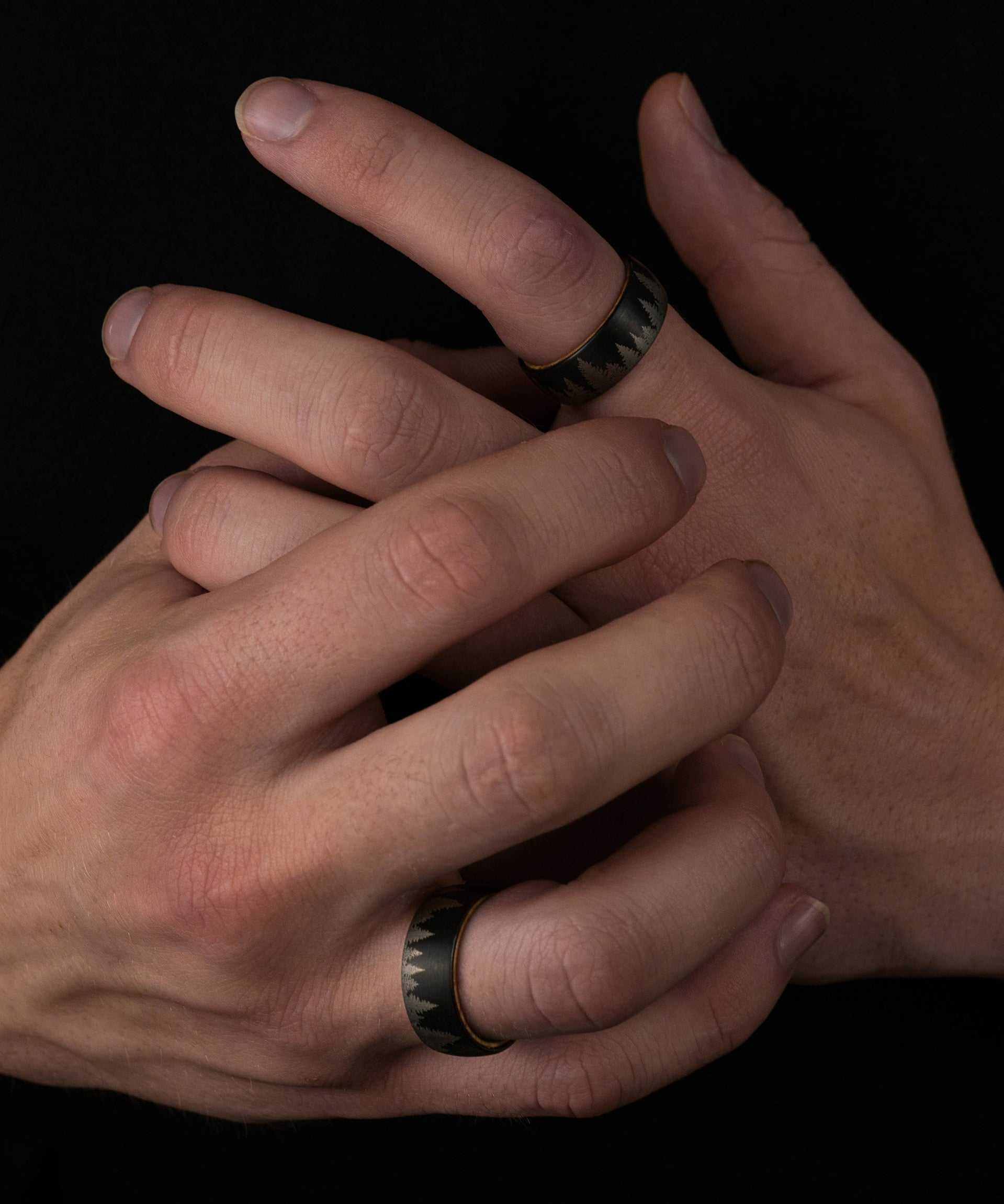 Pine Tree Forest Ring with tungsten band and forest etching on hand.